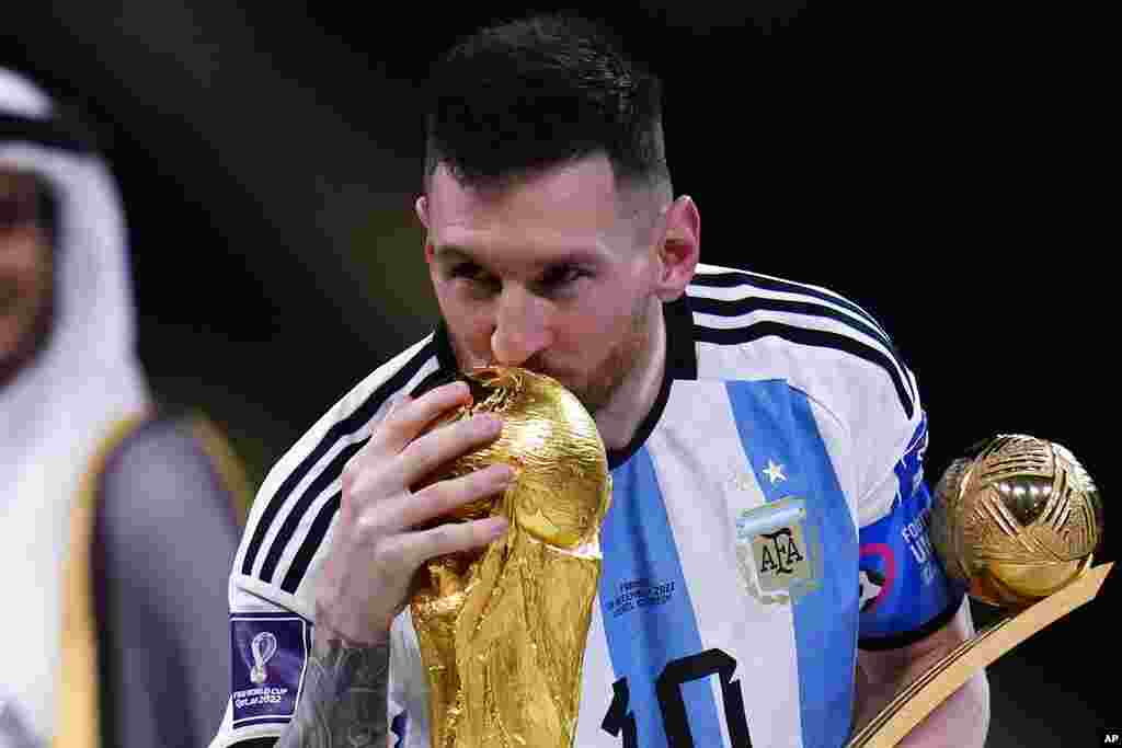 Bintang Argetina Lionel Messi berhasil melengkapi karirnya yang cemerlang. Messi mencium trofi setelah memenangkan pertandingan final Piala Dunia antara Argentina vs. Prancis di Stadion Lusail, Qatar, Minggu, 18 Desember 2022. (Foto: AP)&nbsp;