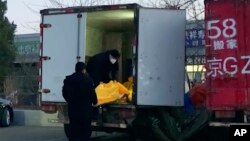 Nhân viên chất các túi đựng thi thể lên xe tải tại một khu nhà tang lễ ở Bắc Kinh, ngày 16 tháng 12 năm 2022.