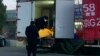 Workers load body bags into a truck at a funeral complex in Beijing, Dec. 16, 2022.