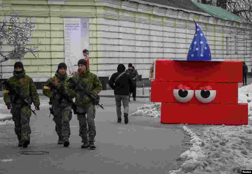 La Navidad en tiempos de guerra se refleja claramente en las calles de Kiev, Ucrania, donde los ciudadanos transitan en medio de soldados y&nbsp; barricadas pintadas de colores.