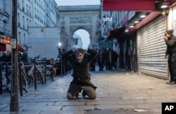 Seorang anggota komunitas Kurdi berlutut di tanah saat dia ditahan akibat bentrok dengan petugas polisi di dekat TKP tempat terjadinya penembakan di Paris, 23 Desember 2022. (Foto: AP)