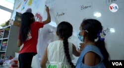 Dos niñas venezolanas observan a una de sus profesoras de Save the Children en una de las aulas de clase en el departamento colombiano de Norte de Santander, fronterizo con Venezuela. FOTO: Nicole Sandoval, VOA.