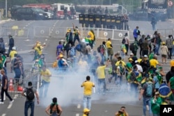 Protesting supporters of former Brazilian President Jair Bolsonaro clash with police during a protest outside the Planalto Palace building in Brasilia, Brazil, Jan. 8, 2023. (AP Photo/Eraldo Peres)