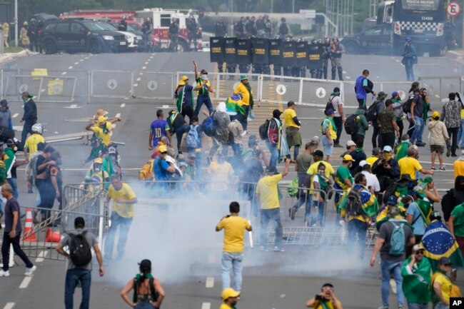 Protesting supporters of former Brazilian President Jair Bolsonaro clash with police during a protest outside the Planalto Palace building in Brasilia, Brazil, Jan. 8, 2023. (AP Photo/Eraldo Peres)