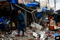A woman passes by a city market that was damaged following Russian shelling, in Kurakhove, Donetsk region, Ukraine, Dec. 8, 2022.