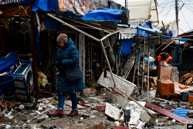 A woman passes by a city market that was damaged following Russian shelling, in Kurakhove, Donetsk region, Ukraine, Dec. 8, 2022.