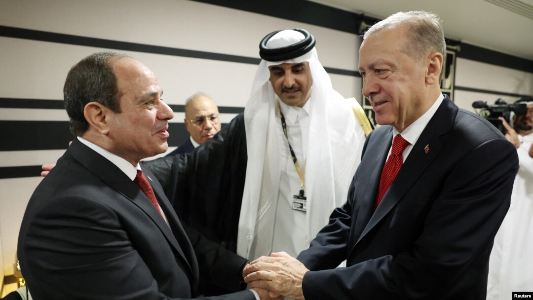 Erdoğan, Katar Emiri Şeyh Temim bin Hamed Al Sani’nin daveti üzerine 2022 FIFA Dünya Kupası’nın açılışı nedeniyle bulunduğu Doha’da Mısır Cumhurbaşkanı Sisi’yle tokalaşırken.