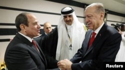 Erdoğan, Katar Emiri Şeyh Temim bin Hamed Al Sani’nin daveti üzerine 2022 FIFA Dünya Kupası’nın açılışı nedeniyle bulunduğu Doha’da Mısır Cumhurbaşkanı Sisi’yle tokalaşırken.