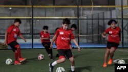 Anak-anak berlatih di lapangan sepak bola di Akademi Olahraga Cedars di ibu kota Qatar, Doha, 8 November 2022. (KARIM JAAFAR/AFP)