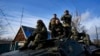 Ukrainian soldiers ride atop an armored vehicle near Bakhmut, Donetsk region, Ukraine, Dec. 22, 2022.