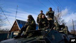 Ukrainian soldiers ride atop an armored vehicle near Bakhmut, Donetsk region, Ukraine, Dec. 22, 2022.
