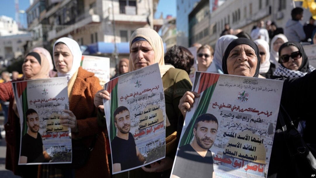 Warga Palestina memegang poster tahanan Palestina Nasser Abu Hamid selama protes, Selasa, 20 Desember 2022, di kota Ramallah, Tepi Barat, setelah dia meninggal karena kanker paru-paru di Israel. (AP/Majdi Mohammed)