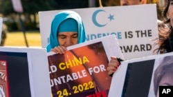 Ashigul Nushirwan protests against China and in support of the Uyghur people in the wake of the Urumqi fire in China, Nov. 28, 2022, during a protest outside of the State Department in Washington. 