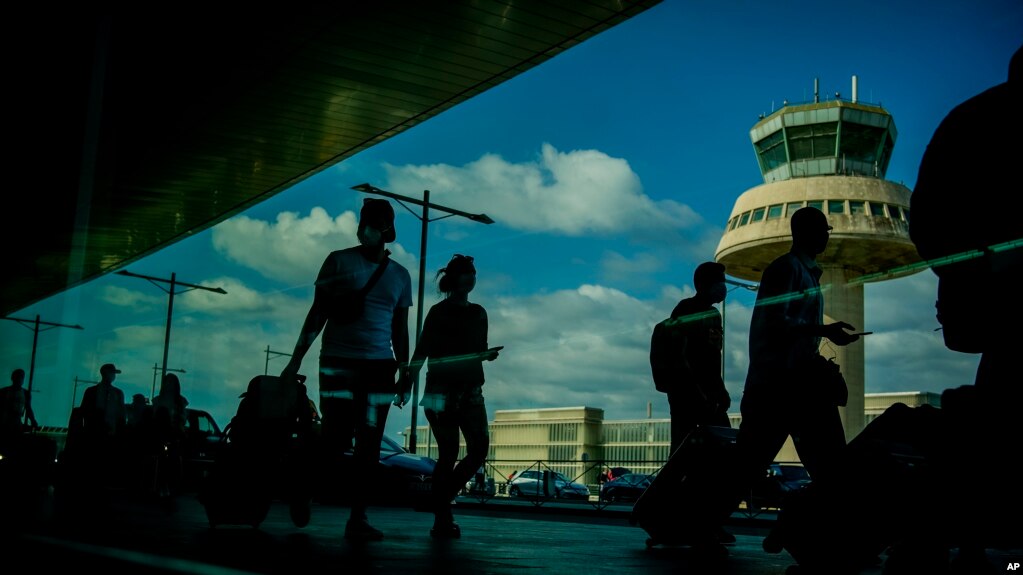 资料照片：2021年7月9日，乘客在西班牙巴塞罗那机场拖着行李走过。（美联社照片）(photo:VOA)