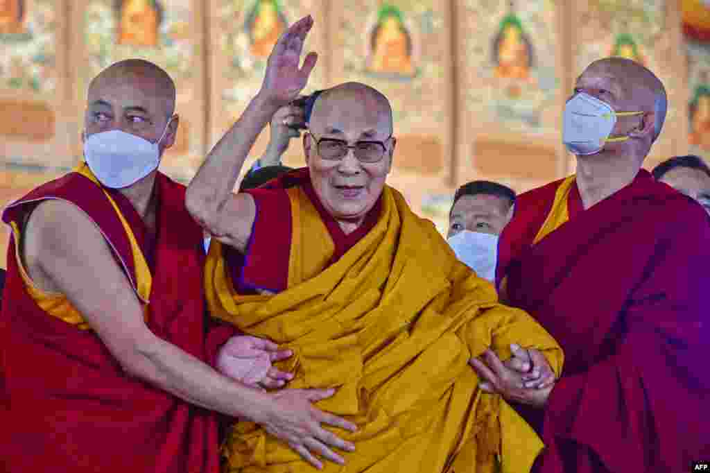 Tibetan spiritual leader Dalai Lama waves during his first day of teaching session at the Kalachakra Ground in Bodhgaya, India.