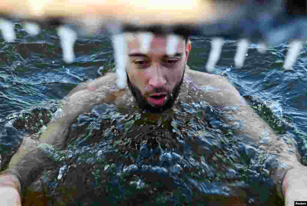 Un hombre nada en las aguas heladas del río Irtysh en el día de apertura de la temporada de natación de invierno en Omsk, Rusia. REUTERS/Alexey Malgavko.