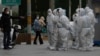 Workers in protective gear gather for their duties in Beijing, Nov. 28, 2022. 