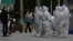Workers in protective gear gather for their duties in Beijing, Nov. 28, 2022. 
