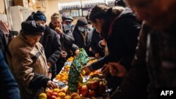 Local residents gather around an impromptu Christmas Eve table to serve themselves at a humanitarian aid center in Bakhmut, Donetsk region, Jan. 6, 2023, as the Russia-Ukraine war enters its 316th day.