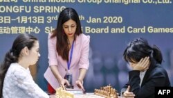 FILE - FILE - Shohreh Bayat (C), chief arbiter for the match between Aleksandra Goryachkina (front L) of Russia and Ju Wenjun (front R) of China, prepares for the match during the 2020 International Chess Federation Women's World Chess Championship in Shanghai on Jan. 11, 2020.