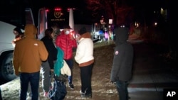 This image provided by WJLA shows migrant families as they get on to a bus to transport them from near the vice president's residence to an area church after they arrived in Washington, Dec. 24, 2022. (WJLA via AP)