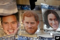 Masker bergambar Pangeran William kiri, Pangeran Harry, tengah, dan istrinya Meghan, kanan, terlihat dijual di sebuah toko di London, Jumat, 6 Januari 2023. (Foto: AP)