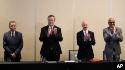 FILE - Venezuelan opposition delegate Gerardo Blyde Perez, Mexican Foreign Minter Marcelo Ebrad, Norwegian diplomat Dag Nylander and National Assembly President Jorge Rodriguez applaud after signing a pact to create a fund for the poor, at a meeting in Mexico City, Nov. 26, 2022.