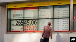 Indeks Nikkei 225 Jepang dan harga saham di sebuah perusahaan sekuritas di Tokyo, Selasa, 27 Desember 2022. Saham Asia menguat setelah China mengumumkan akan lebih melonggarkan pembatasan pandemi, Selasa, 27 Desember 2022.(AP/Hiro Komae)