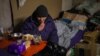 FILE - An elderly man reacts as he sits in a basement used as a bomb shelter in Bakhmut, Donetsk region, Dec. 2, 2022. 