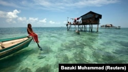 Seorang gadis Bajau Laut berjemur di perahunya di lingkungannya di Laut Sulawesi di negara bagian Sabah Malaysia, Kalimantan 17 Februari 2009. (Foto: REUTERS/Bazuki Muhammad)