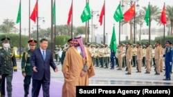 In this photo provided by the Saudi Press Agency, Saudi Crown Prince Mohammed Bin Salman welcomes Chinese President Xi Jinping in Riyadh, Saudi Arabia, Dec. 8, 2022. 