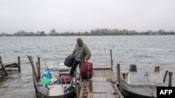A man leaves his home for his summer residence on an island in the Dnipro River after an attack on an oil reserve in Kherson on Nov. 20, 2022, amid the Russian invasion of Ukraine.