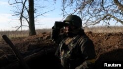 A member of the 68th Independent Jager Brigade of the Ukrainian Army scans the horizon for Russian military from his position in the trenches near the frontline in the Southern Donbas region in Ukraine, Nov. 29, 2022.REuters/Leah Millis