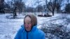 Nina Klinkova reacts to a sound of an explosion as she looks for humanitarian aid in Siversk, Donetsk region, Ukraine, Jan. 12, 2023.