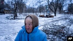 Nina Klinkova reacts to a sound of an explosion as she looks for humanitarian aid in Siversk, Donetsk region, Ukraine, Jan. 12, 2023.