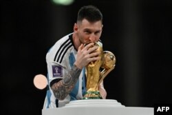 Argentina's captain and forward #10 Lionel Messi kisses the FIFA World Cup Trophy during the trophy ceremony after Argentina won the Qatar 2022 World Cup final football match between Argentina and France at Lusail Stadium in Lusail, north of Doha, Qatar, Dec. 18, 2022.