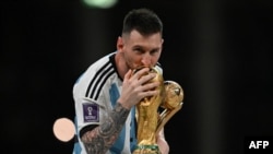 FILE: Argentina's captain and forward #10 Lionel Messi kisses the FIFA World Cup Trophy during the trophy ceremony after Argentina won the Qatar 2022 World Cup final football match between Argentina and France at Lusail Stadium in Lusail, north of Doha on December 18, 2022