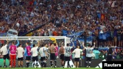 Los jugadores de la selección de Argentina celebran con sus aficionados.