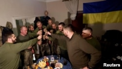 Ukrainian soldiers share a toast to celebrate New Years Eve, in a military rest house, as Russia's attack on Ukraine continues, in region of Donetsk, Ukraine, Dec. 31, 2022.