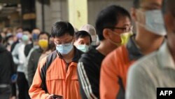 People queue at a polling station to vote in the mayoral elections in New Taipei City on Nov. 26, 2022. 