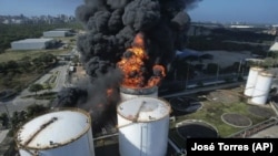 Grandes llamas escapan del contenedor de almacenamiento de gasolina en Bravo Petroleum en Barranquilla, Colombia, el 21 de diciembre de 2022.