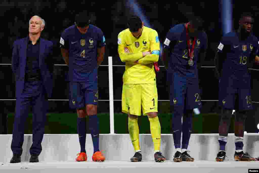 France coach Didier Deschamps, Raphael Varane, Hugo Lloris, Ibrahima Konate and Dayot Upamecano look dejected after they are awarded with their runners up medals at the Lusail Stadium in Lusail, Qatar.