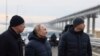 Presiden Rusia Vladimir Putin (tengah) dan sejumlah pejabat pemerintahan Rusia berkunjung ke area Jembatan Krimea yang menghubungkan wilayah daratan Rusia dengan Semenanjung Krimea pada 5 Desember 2022. (Foto: Mikhail Metzel, Sputnik, Kremlin Pool Photo via AP)