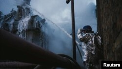 A firefighter works at a site of a critical power infrastructure object, which was hit during Russia's drones attacks in Kyiv, Dec. 19, 2022. (Press service of the State Emergency Service of Ukraine/Handout via Reuters)