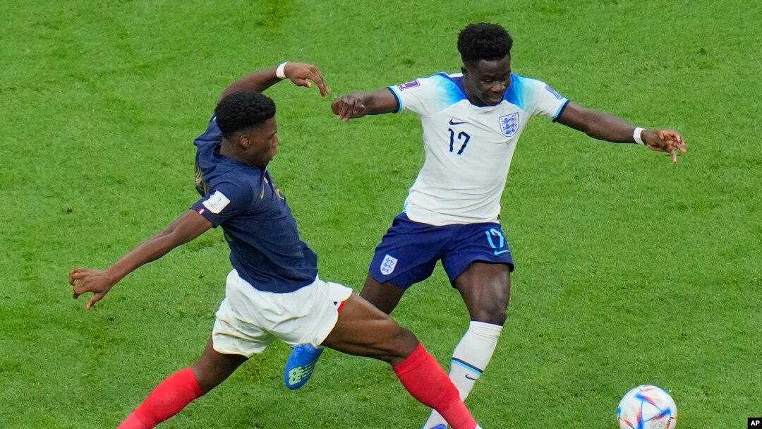 France's Aurelien Tchouameni, left, challenges for the ball with England's Bukayo Saka during the World Cup quarterfinal soccer match between England and France, at the Al Bayt Stadium in Al Khor, Qatar, Dec. 10, 2022. France beat England 2-1.