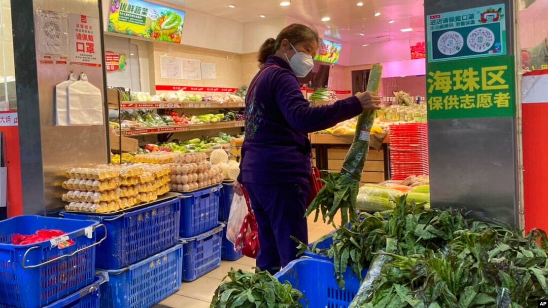 A woman shops in a reopened grocery store in the district of Haizhu as pandemic restrictions are eased in southern China's Guangzhou province, Dec. 1, 2022.