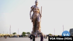 FILE - A statue of one of the female warriors of Dahomey in Cotonou Benin draws visitors from around the country. Image captured by VOA's Henry Wilkins.