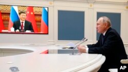 Presiden Rusia Vladimir Putin di Kremlin berbicara dengan pemimpin China Xi Jinping lewat sebuah telekonferensi video hari Jumat (30/12).