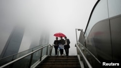 上海陆家嘴金融区的行人在雨中行走。（2022年12月9日）