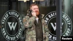Un hombre habla por teléfono fuera del Centro PMC Wagner, un proyecto creado por el empresario y fundador del grupo militar privado Wagner, Yevgeny Prigozhin, durante la inauguración oficial del edificio de oficinas en San Petersburgo, Rusia, el 4 de noviembre de 2022.